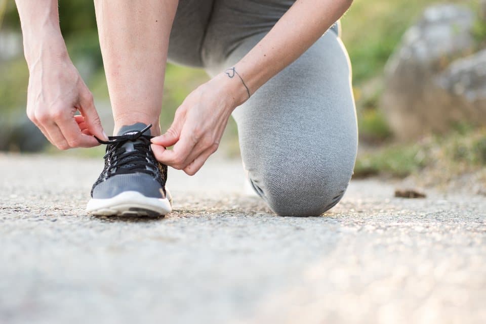 Personne nouant son lacet de chaussure de sport
